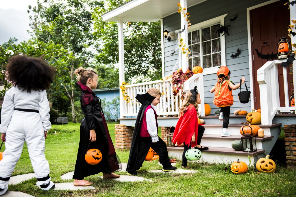 Young children trick or treat on Halloween