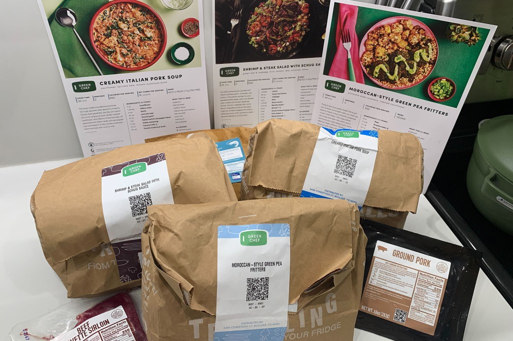 Three green chef meals and recipe cards on a counter