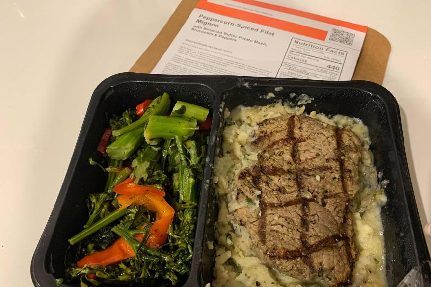 A steak and potatoes on a tray